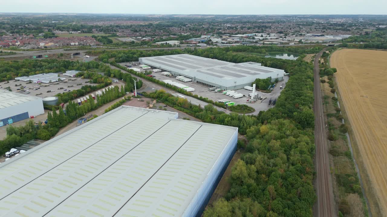 Drone aerial view of Bedford UK distribution centres and factories with heavy transport trucks and trailers engaged in cargo loading and unloading