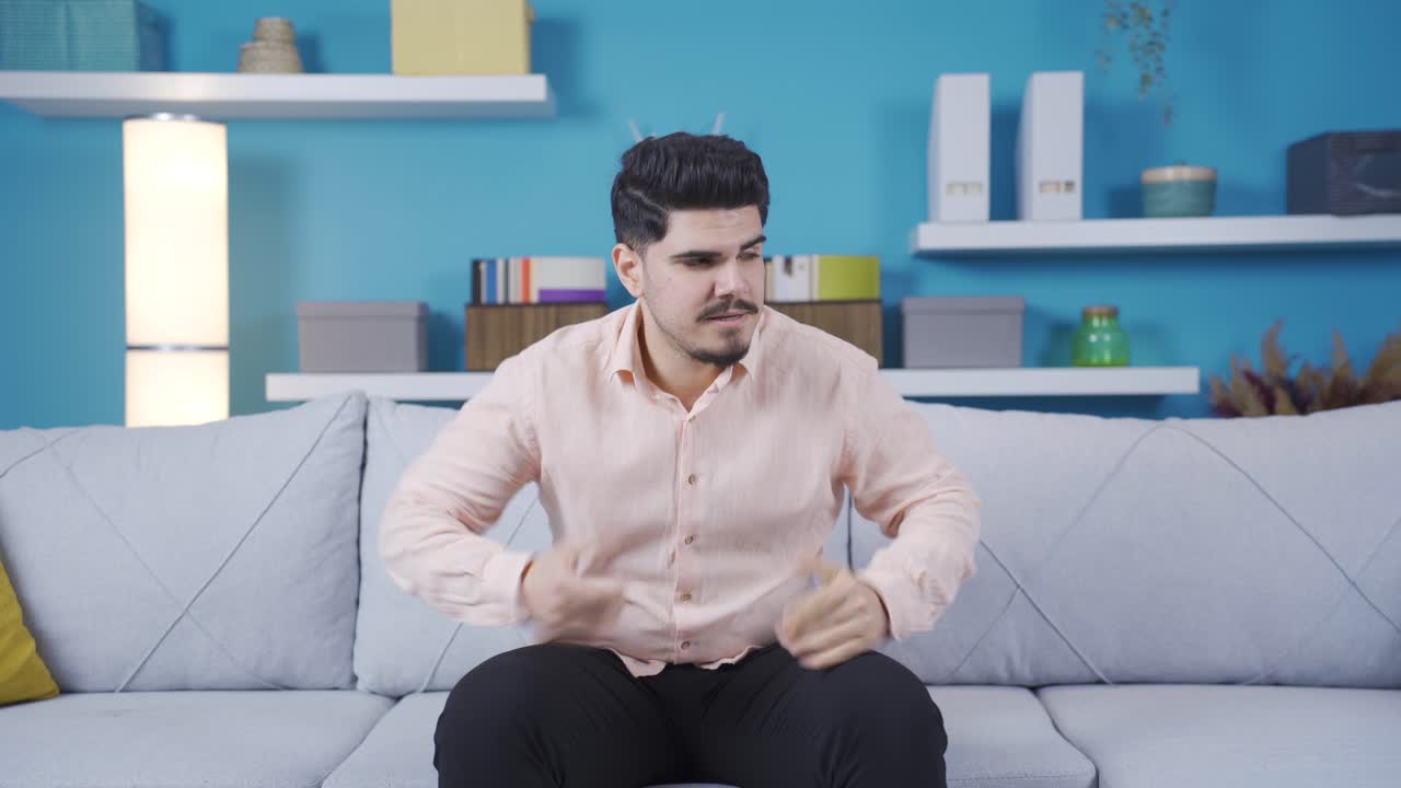 좌절된 젊은이가 집에서 화를 내고 있습니다.