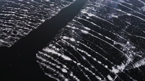 a trail of crumbling pieces of ice floating on a lake surface
