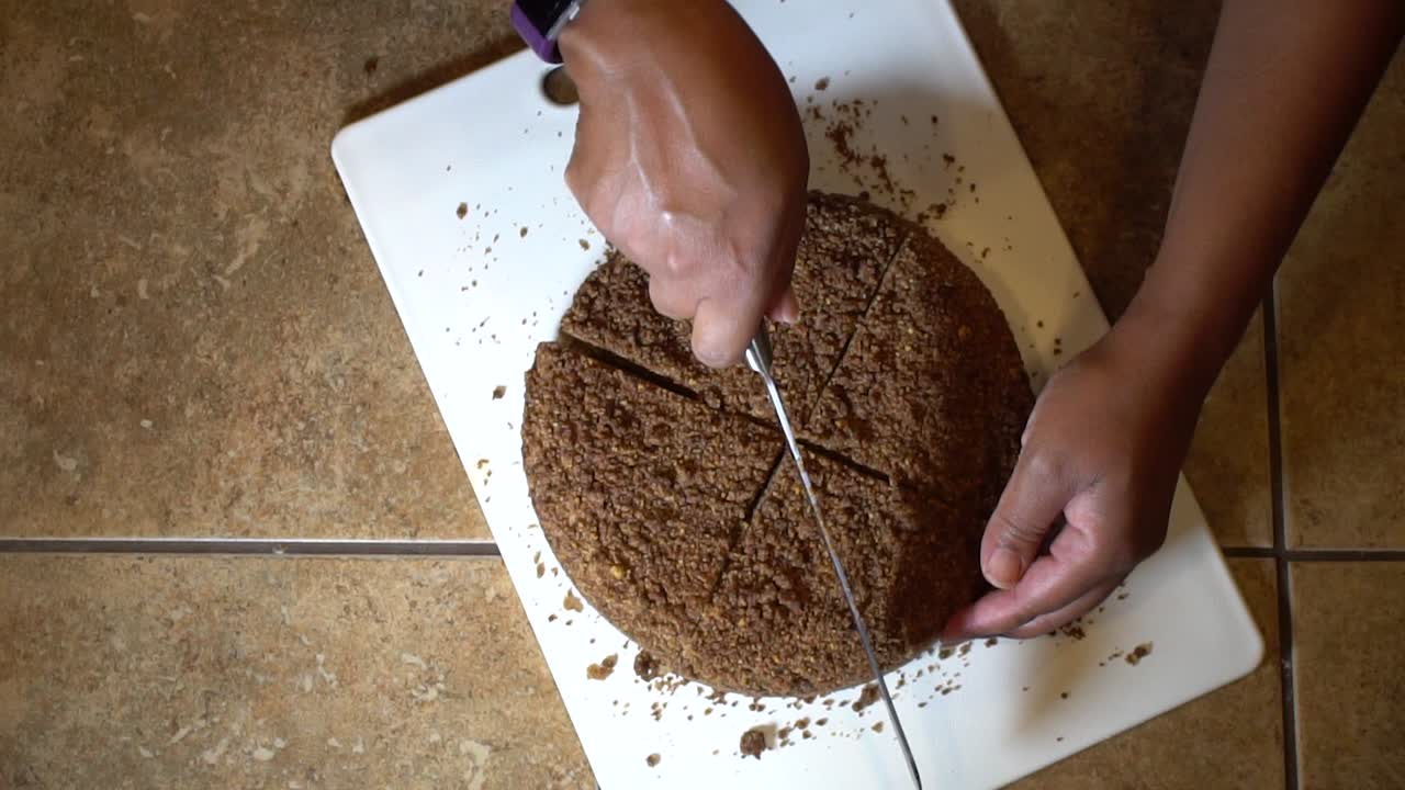 timelapse, mujer cortando pastel de chocolate entero en rodajas, primer plano de arriba