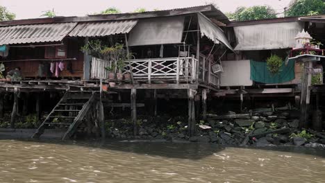 Old-houses-built-on-the-banks-of-a-canal-in-the-city-of-Bangkok,-Thailand