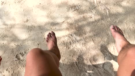 feet of a man swinging sideways in sairee beach, koh tao, thailand in summer - high angle, pov