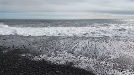 in perfect sync, the waves and cloudy sky create a breathtaking display of natural harmony, black sand beach