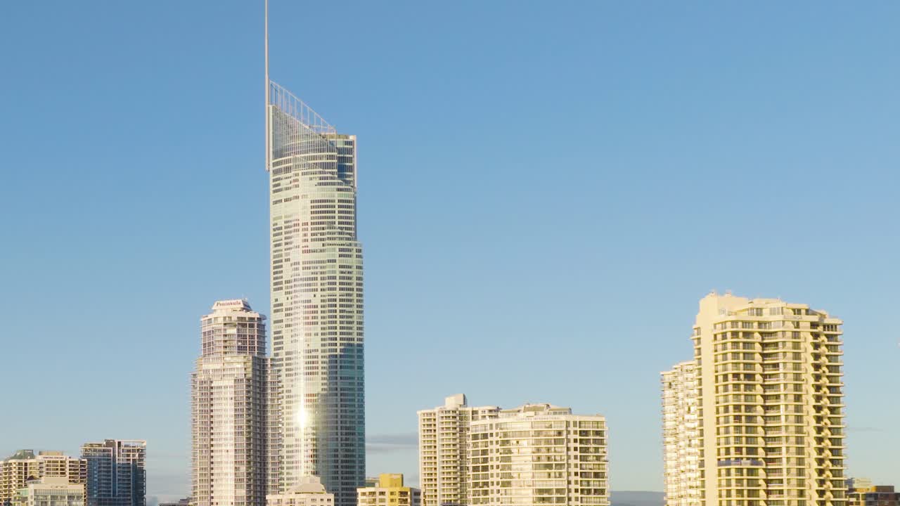 Edifícios altos sob luz do dia brilhante com céus claros na Gold Coast, Austrália. Câmera estática captura o horizonte urbano.