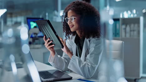 científico en un laboratorio usando una tableta y una computadora portátil