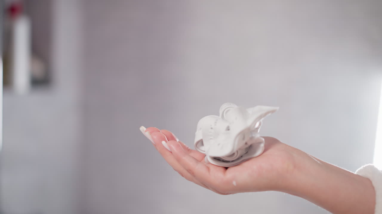 사람이 샤워에서 튜브에서 물에 용해되는 영양있는 샤워 젤을 압축합니다. 절차가 끝난 후 여성은 신체 제품으로 목욕을 하고 싶어합니다.