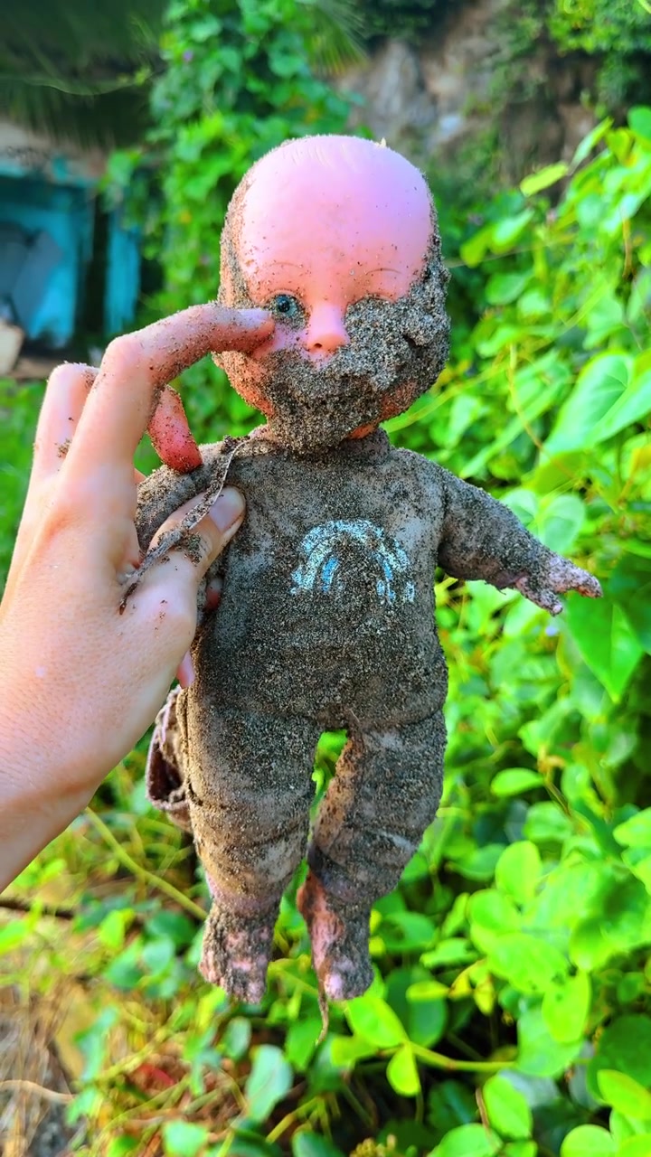 Verlassene Puppe in tropischer Vegetation. Alte verlassene Puppe, mit Sand bedeckt, inmitten tropischer Vegetation.