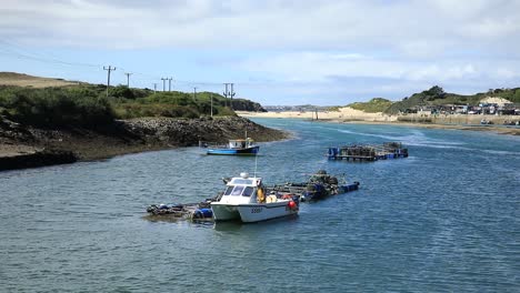 White-Boat-Anchored-In-Hayle-Town-Port,-Blue-Water,-Cornwall,-England