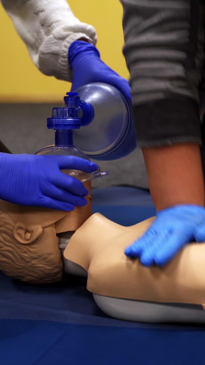 Training on a medical mannequin. People doing cardiopulmonary resuscitation. Procedure of chest compression on a dummy. Vertical video