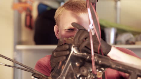 Close-Up-of-Young-Blonde-Man-Unscrewing-Headpiece-During-Motorcycle-Teardown