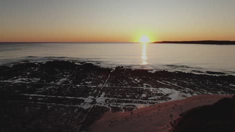 puesta de sol sobre las piscinas de roca de la playa, antena