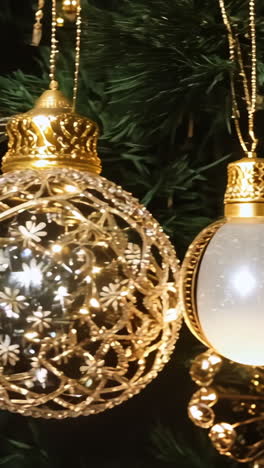 a christmas tree with a red and gold ornament hanging from it. the gold ornament is larger than the red one