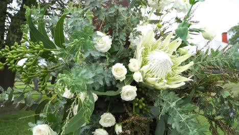 outdoor wedding ceremony setup, wedding arch decorated with white flowers - close up