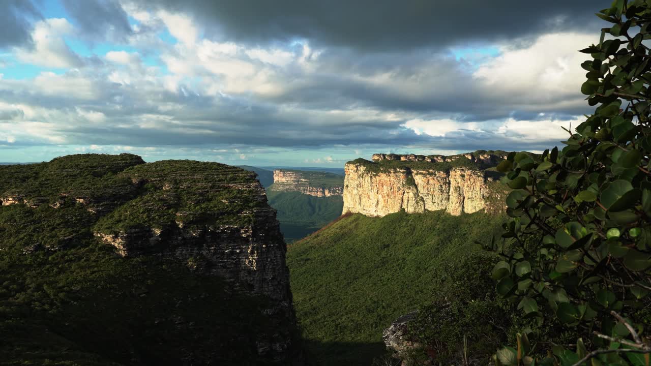 Tilting down shot revealing the stunning Capao Valley with large plateaus from the Mount of Pai Inácio hike in the Chapada Diamantina national park in northern Brazil on a warm summer evening