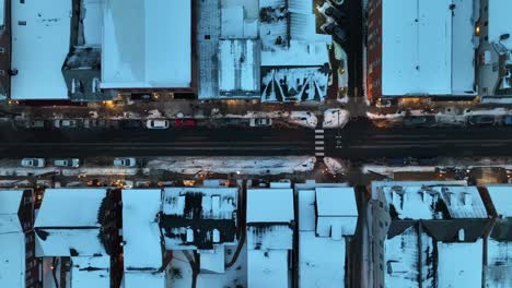 snow covered houses with warm lighting storefronts in american town