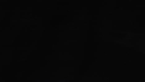 glass slowly cracking and shattering on black background. abstract effect for impact, breaking, or transition. minimalist video
