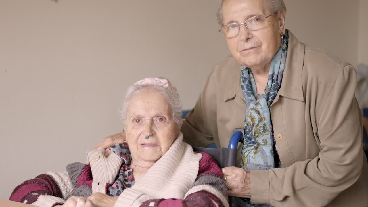 Senior women looking at camera together in a nursing home