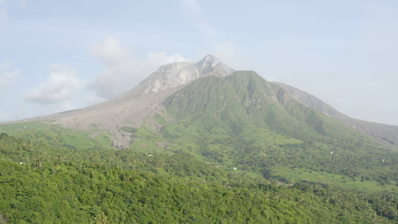 Bidikan dolly maju yang mulus. Gunung berapi aktif di kejauhan dikelilingi hutan lebat. Bagian_2