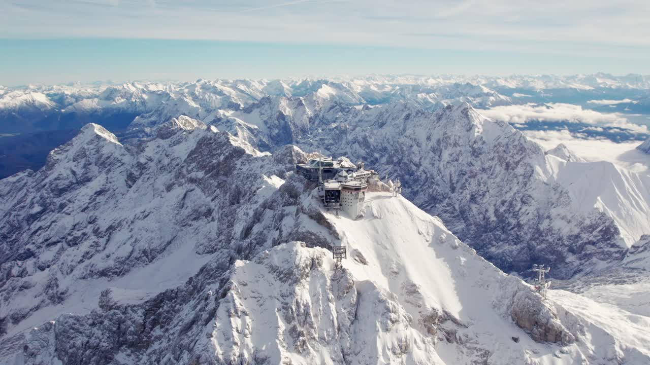 acercándose a la antena de la cumbre del zugspitze en invierno con nubes de nieve y cielo azul