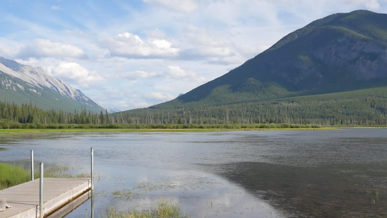 vista panorámica hermosa vista natural de los lagos bermellones con un hermoso muelle de madera que conduce al lago en primer plano y montañas rocosas en el fondo en el parque nacional de banff, alberta, canadá