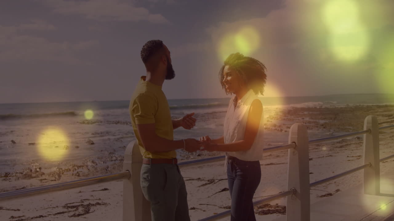 On beach, couple experiencing joyful moment with glowing light animation effects
