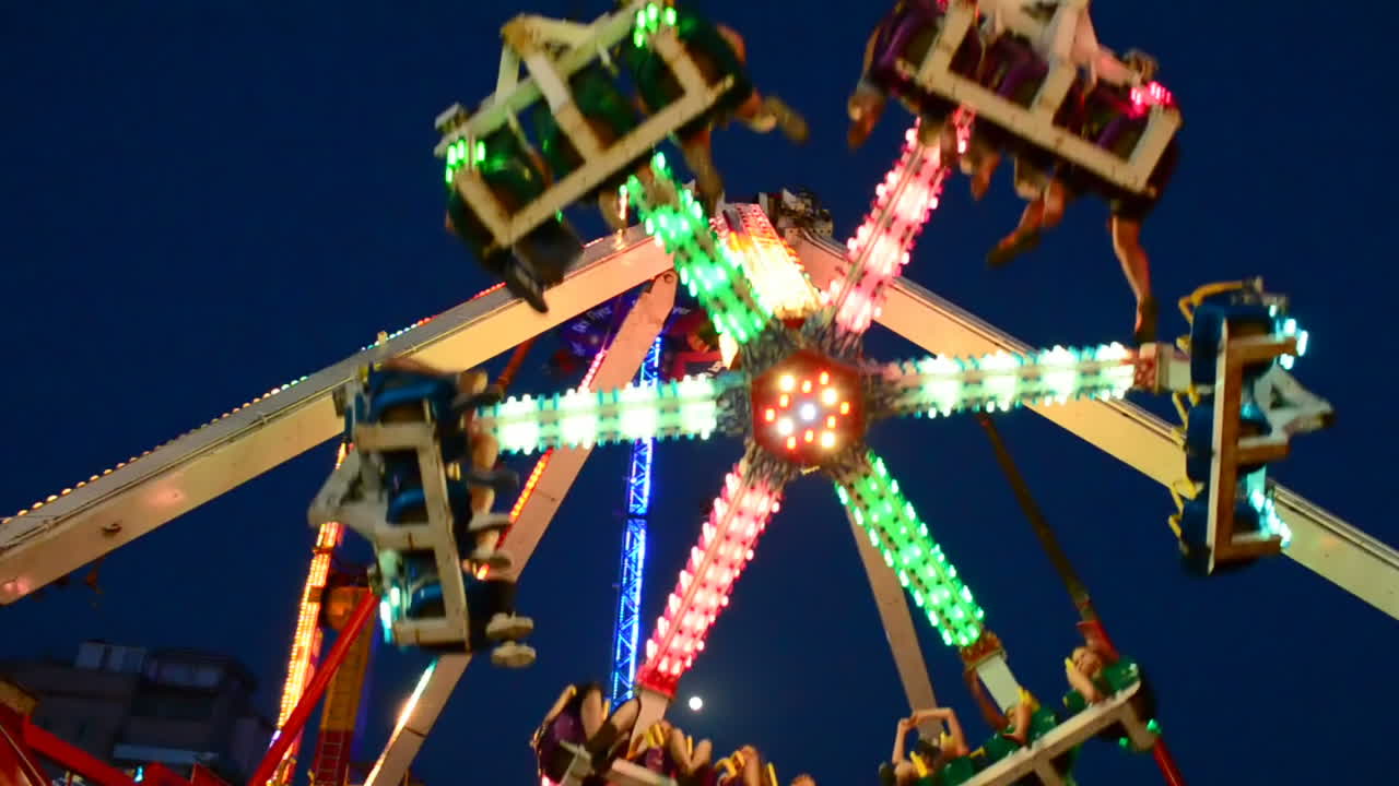 Attraction pendulum. Pendulum in the park. Shooting in the sea resort. Night attractions