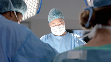 Diverse-female-surgeons-operating-on-patient-in-operating-theatre,-slow-motion