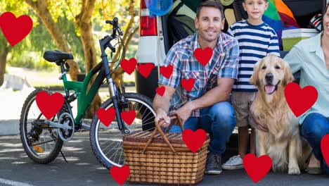 Multiple-red-heart-icons-floating-against-caucasian-family-with-their-pet-dog-on-a-picnic