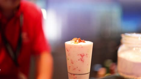 person preparing a smoothie with toppings