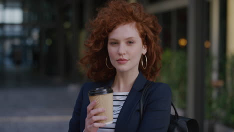 portrait young beautiful red head business woman enjoying successful lifestyle holding coffee wind blowing hair in urban outdoors background ambition success