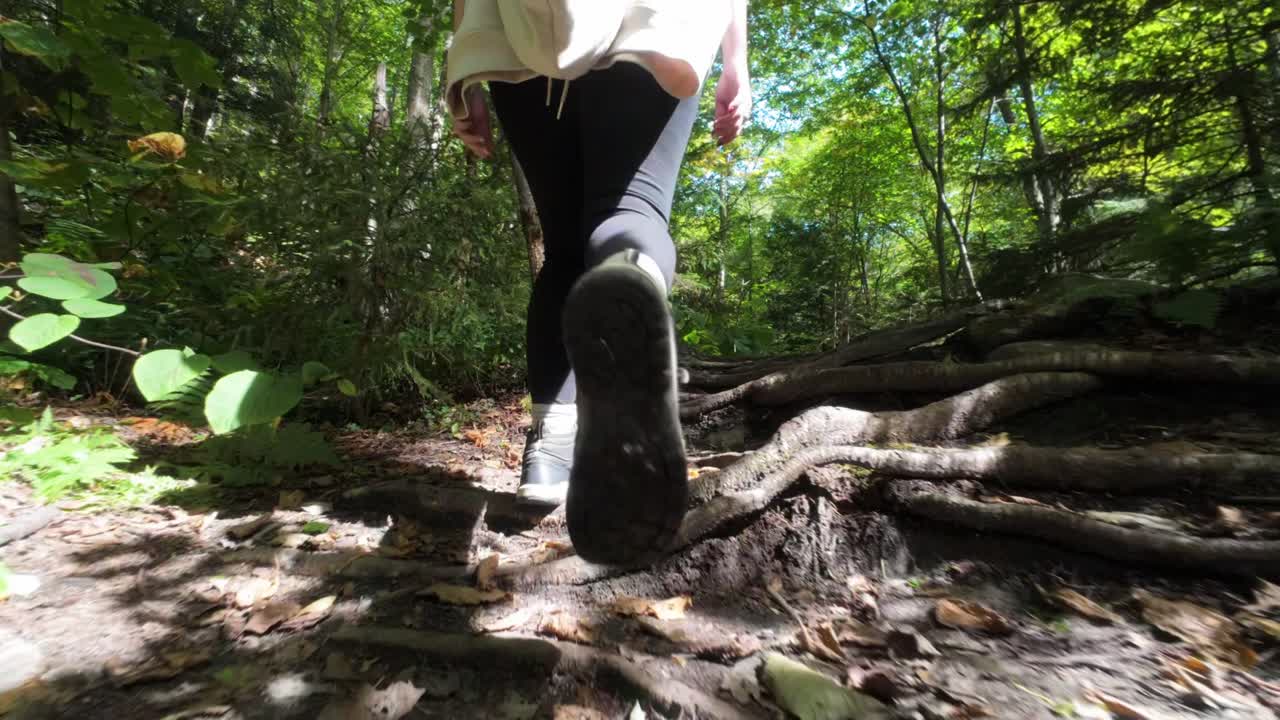 Slow motion footage of a woman hiking on trails of Mount Sutton, Quebec, Canada