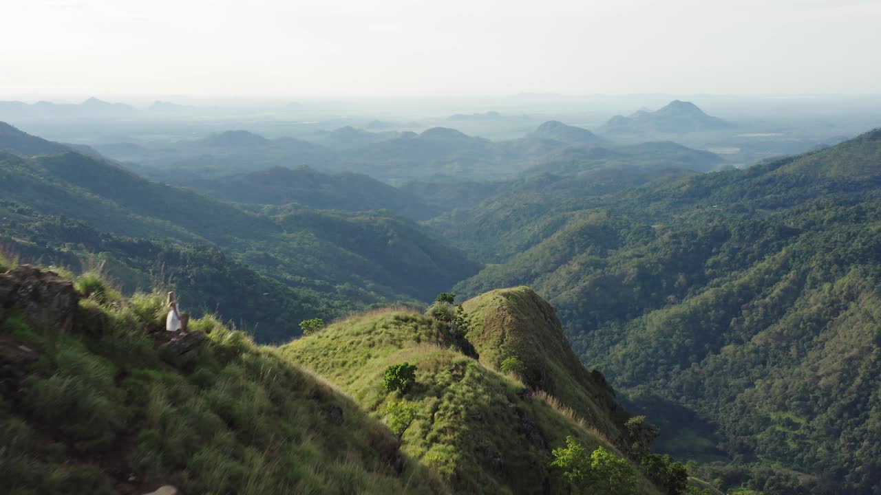 Model wanita bergaun putih menikmati pemandangan pagi yang indah dari Little Adams Peak