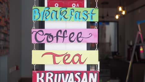 colorful wooden menu sign for breakfast, coffee, tea, and kruvasan