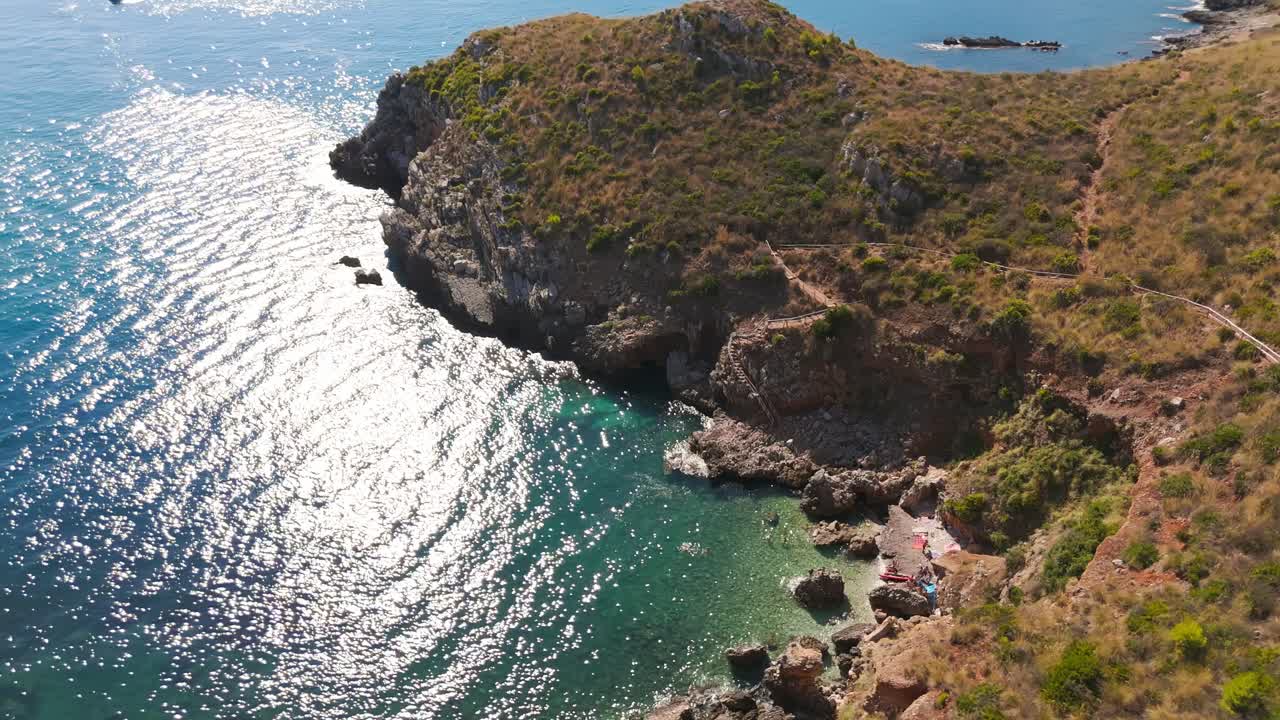 Aerial view of Cala Rossa's rocky coast in Sicily, Italy, under sunlight