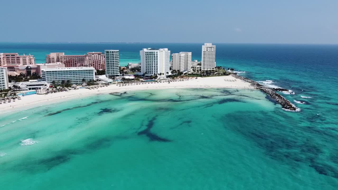 La costa di Cancun con acque limpide e turchesi e vivaci hotel sul lungomare, vista aerea.