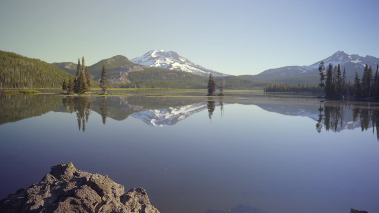 de un lago de montaña con una gran montaña reflejada en el lago
