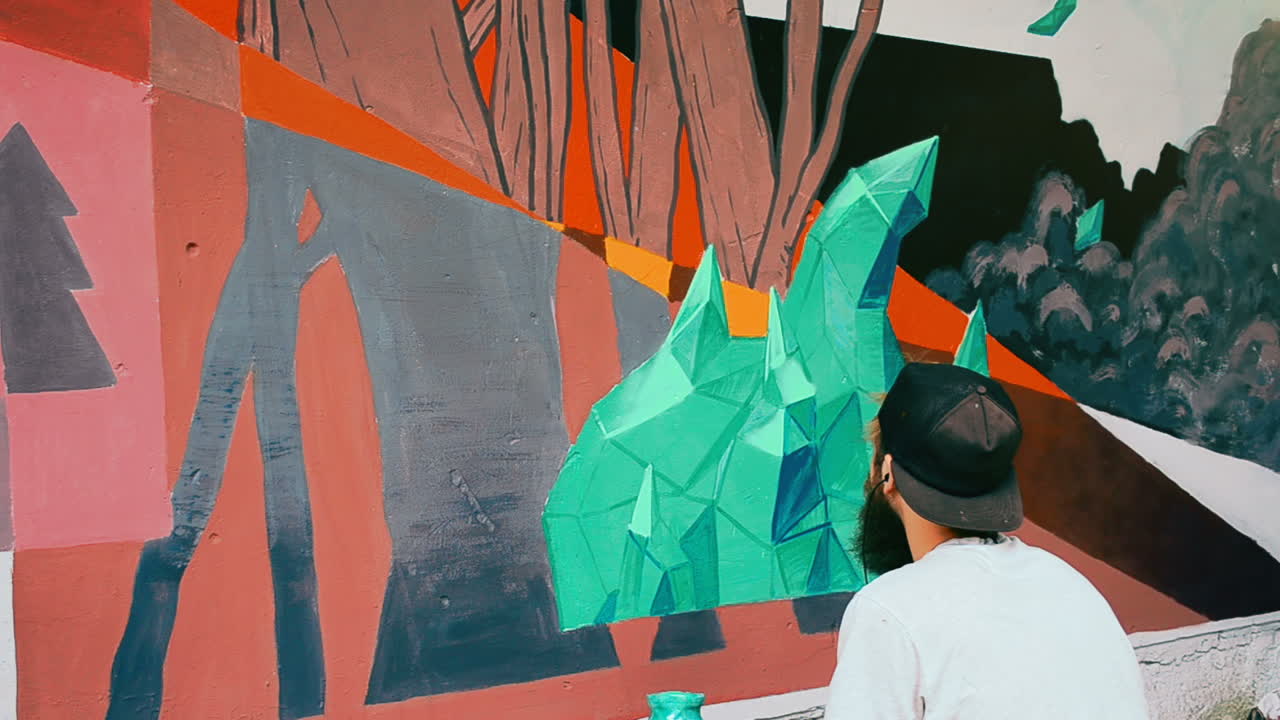 The artists draws graffiti on a fence. Abstract drawing