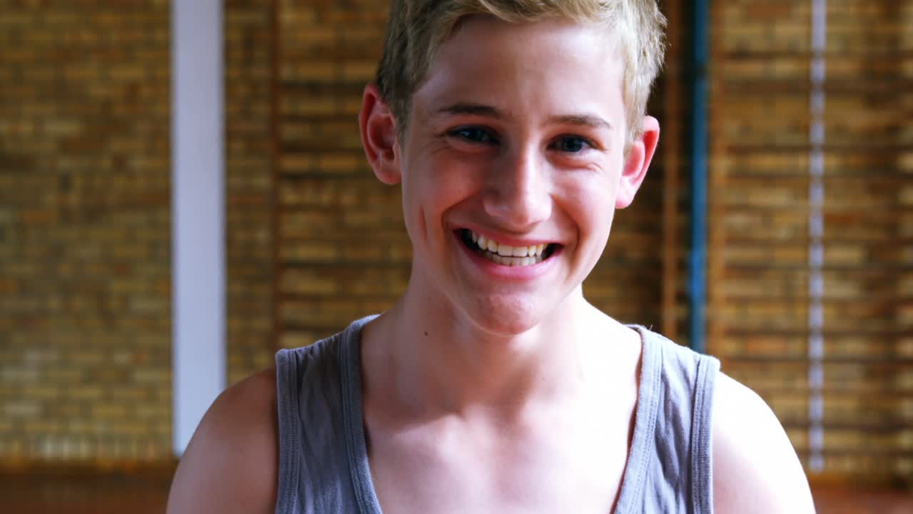 escolar de pie con el baloncesto en la cancha 4k