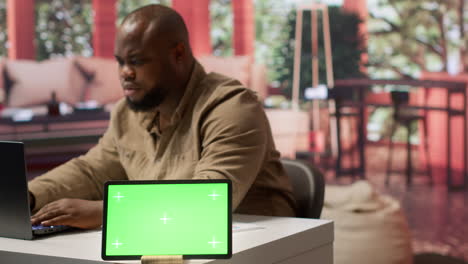 businessman examines annual sales reports on documents next to a green screen