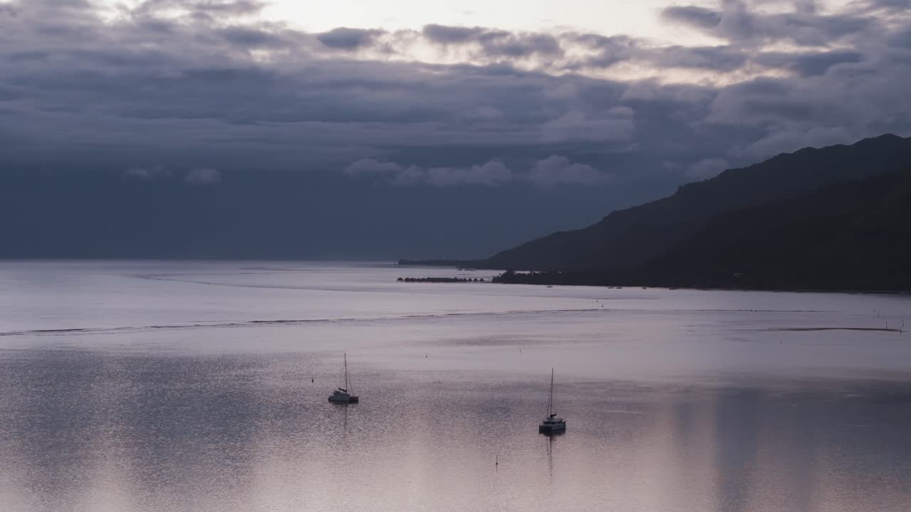 Two Catamarans at Anchor in a Calm Ocean Bay at Sunrise