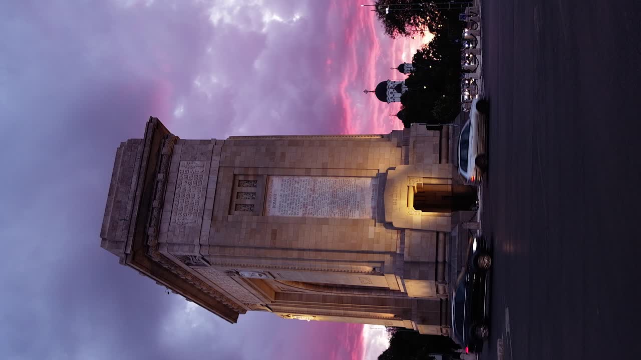 Bucharest, Romania - April 24, 2021: Cars moving near The Triumphal Arch at sunset. Vertical