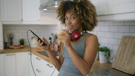 Mujer-Casual-Relajante-Con-Teléfono-En-La-Cocina