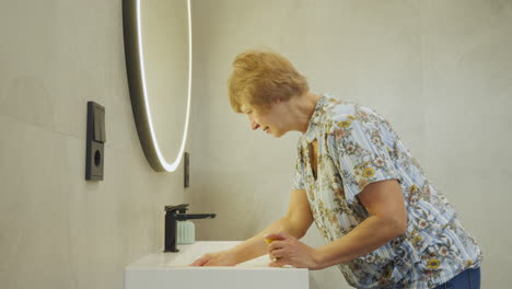 woman washing hands in a modern bathroom