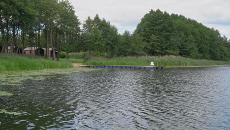 Una-Vista-De-Las-Cabañas-De-Camping-Ubicadas-En-El-Bosque-En-Un-Hermoso-Lago-Con-Un-Muelle