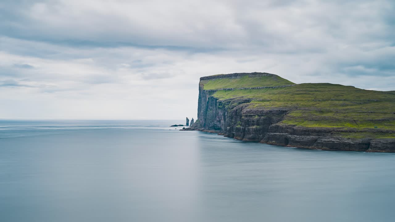 녹색 산과 바다 저속 촬영으로 가파른 절벽 위로 움직이는 구름