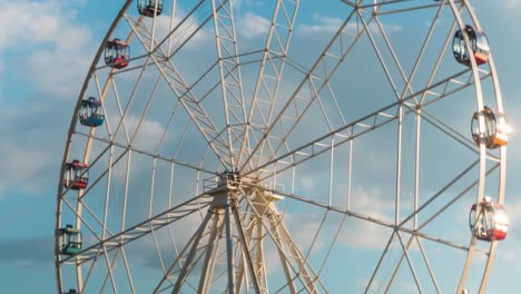 timelapse of rotating ferris wheel and clouds movement, sunset cloudy sky