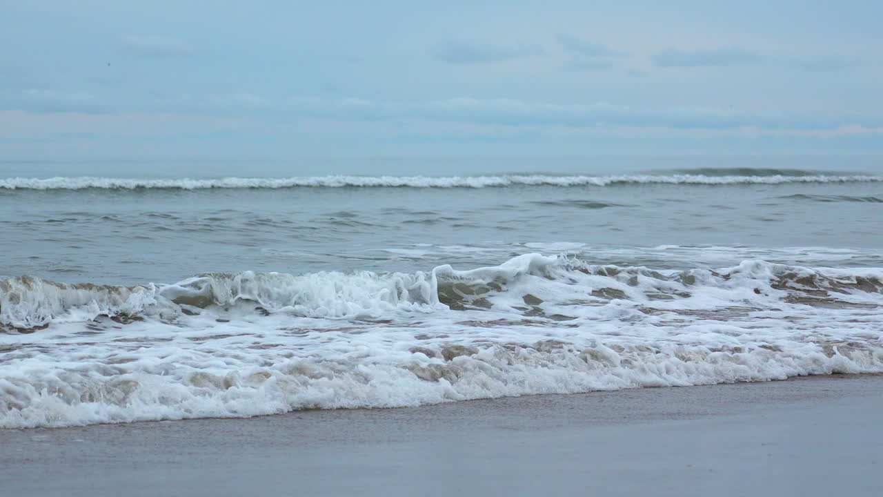 해가 지는 동안 해변의 파도