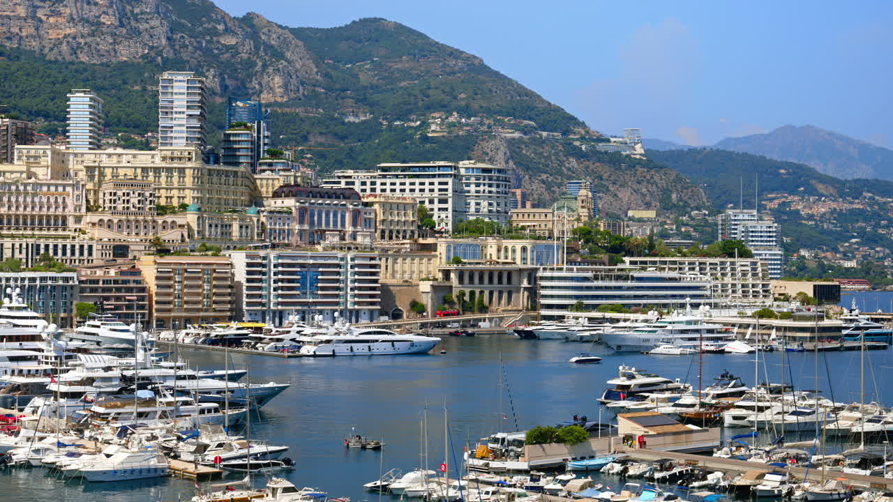 View of boats docked in the Monaco Marina with the skyline of the city on the background