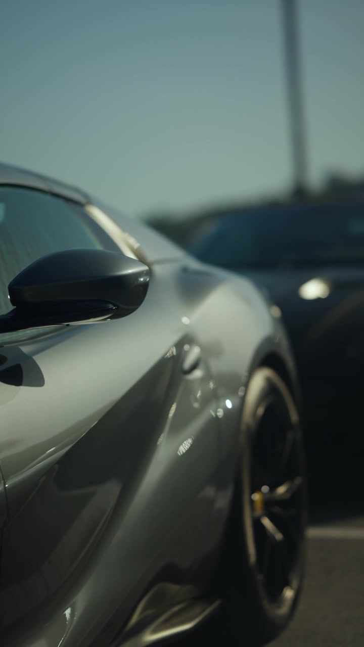 Moderna auto sportiva di lusso con elegante verniciatura grigio metallizzato, che mostra un design automobilistico dinamico e uno specchietto laterale