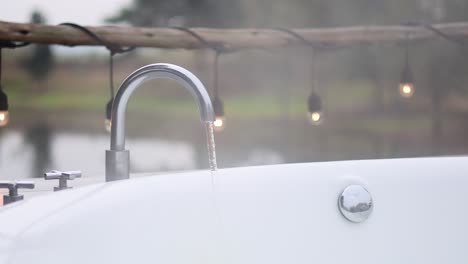 water flowing from a bathtub faucet outdoors